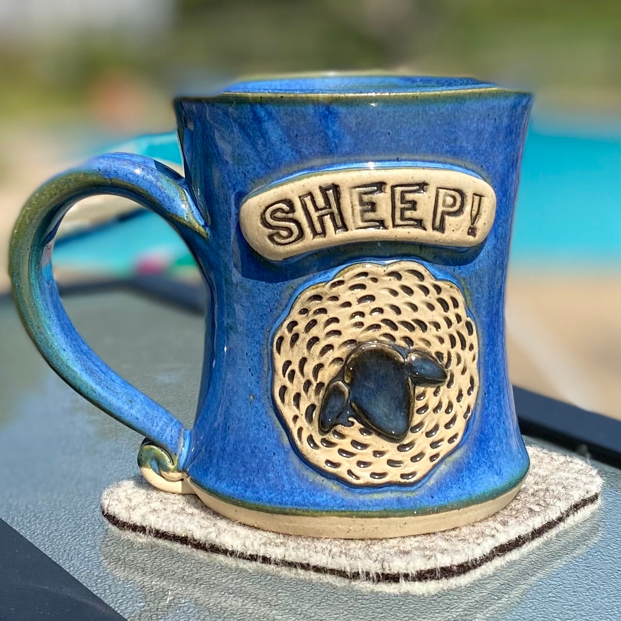 Natural & dark brown coaster shows with blue "sheep" mug. 100% Devilsbliss Farm wool. Coasters are reversible.